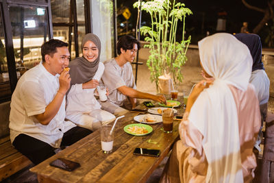 Portrait of smiling friends having food at home