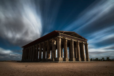 Picturesque long exposure view of ruin of ancient temple against cloudy sky