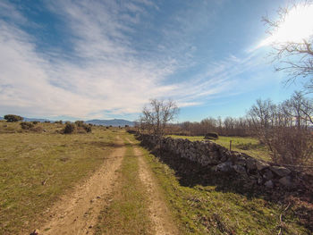 Road amidst field against sky