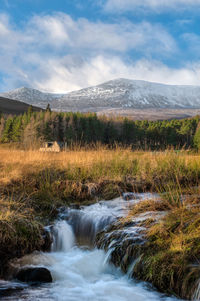 Scenic view of waterfall against sky