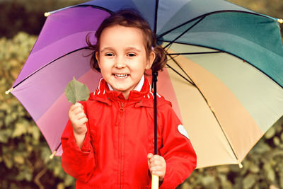 Portrait of smiling girl holding umbrella