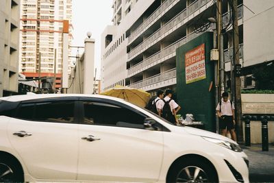 People on street amidst buildings in city