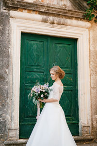 Woman wearing mask against blue door