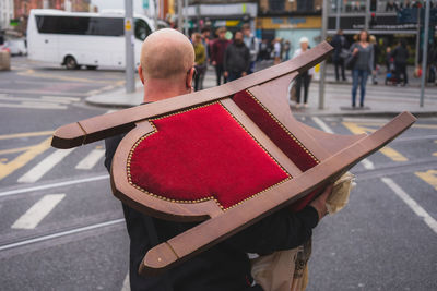 Rear view of man reading book on street