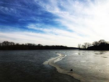 Scenic view of lake against sky during winter