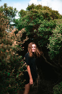 Portrait of smiling woman standing in forest