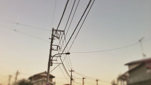 Low angle view of electricity pylon against clear sky