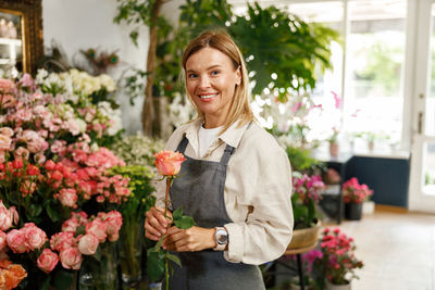 Portrait of smiling young woman holding bouquet