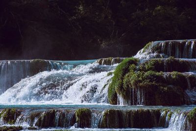 Scenic view of waterfall against sky