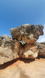 Low angle view of rock formation against clear blue sky