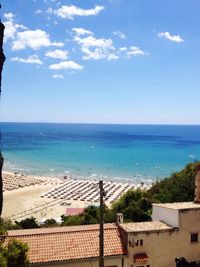 High angle view of houses by sea against sky