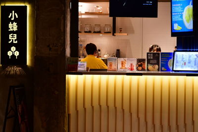 Rear view of people sitting at illuminated restaurant