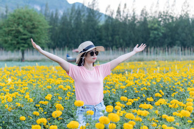 Woman standing on field with yellow flowers