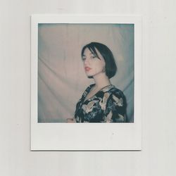 Portrait of young woman looking through window