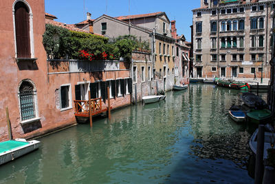 Boats moored on canal in city