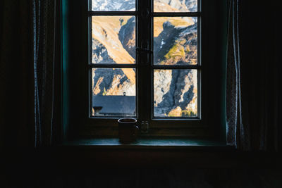 Mountains seen through window at home with tea cup in front