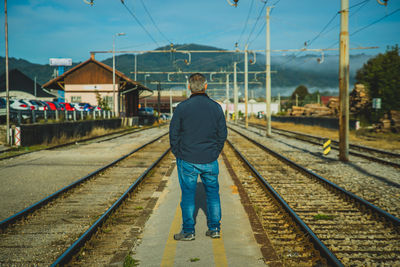 Rear view of man standing on railroad track