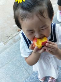 Close-up of girl eating peach