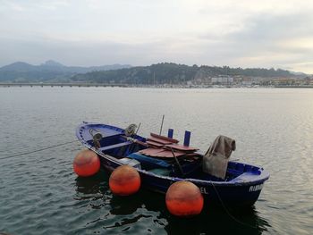 Boats moored in sea against sky