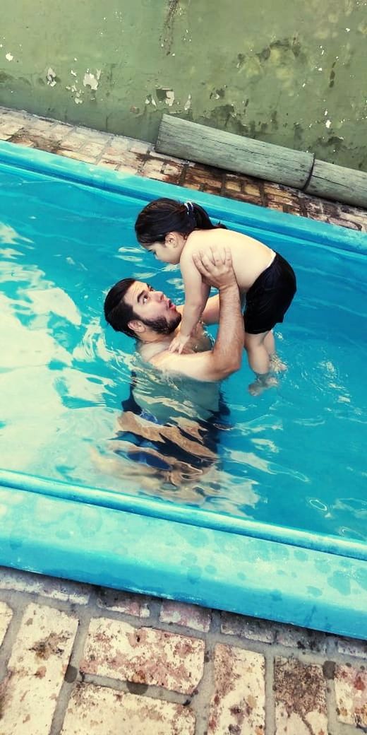 HIGH ANGLE VIEW OF COUPLE SWIMMING IN POOL