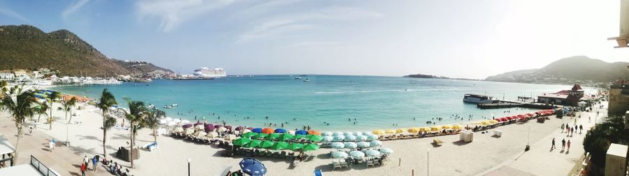 Panoramic view of people on beach against sky