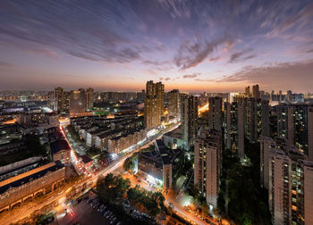 High angle view of illuminated buildings against sky at night