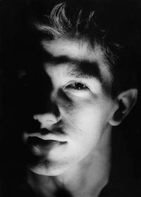 Close-up portrait of man against black background