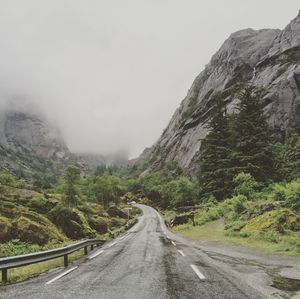 Road passing through mountains against clear sky