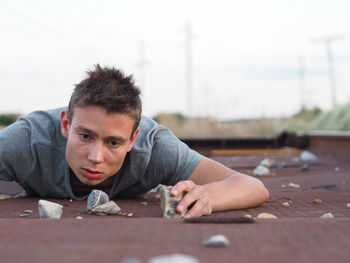 Sad man by stones lying down on footpath