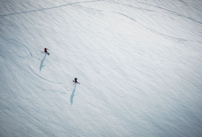 Two men skiing on snow in iceland from overhead angle