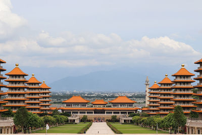 Buildings in city against cloudy sky