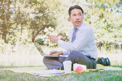 Full length of man sitting in park