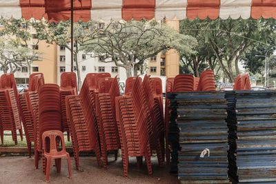 Stacked chairs and tables under tent