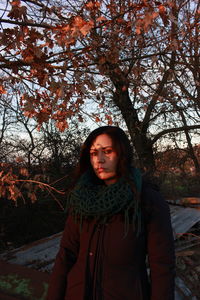 Portrait of young woman standing in park during winter