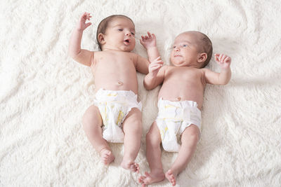 Twin baby boys lying on bed