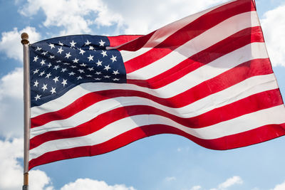 Low angle view of american flag against sky