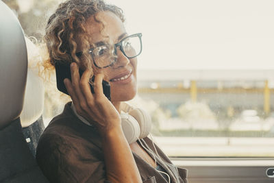 Portrait of young woman drinking water while sitting in car