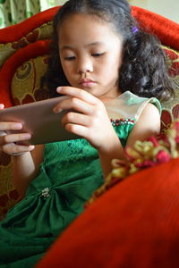 Girl looking away while sitting on mobile phone