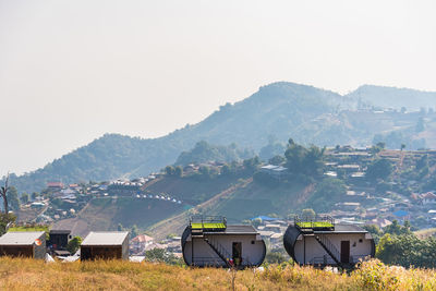 Houses by buildings against clear sky