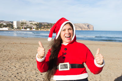 Portrait of smiling young woman standing on beach