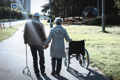 Rear view of senior couple walking on road