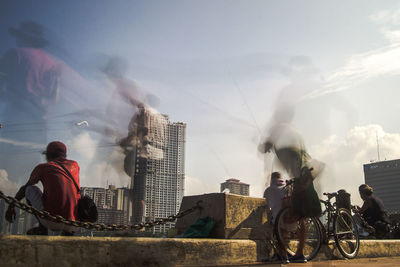 Men in city against sky