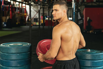 Shirtless man exercising at gym