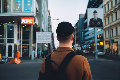 Rear view of man standing on city street