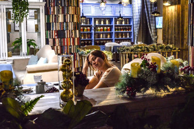 Rear view of woman sitting by christmas tree