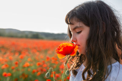 Close-up of young woman holding red flower