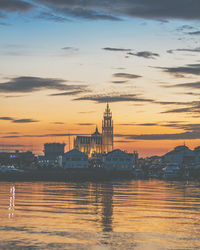 View of buildings at waterfront during sunset