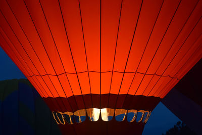 Illuminated orange hot air balloon at dusk