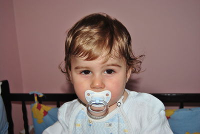 Portrait of baby boy sucking pacifier at home