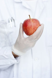 Laboratory technician holding apple